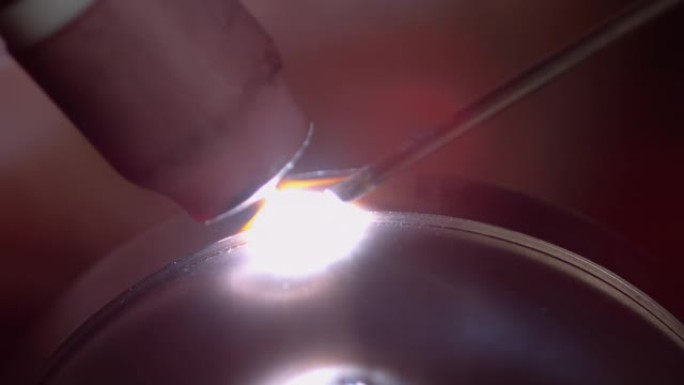 宏观: 焊工在制作消声器时钉一块金属的详细镜头