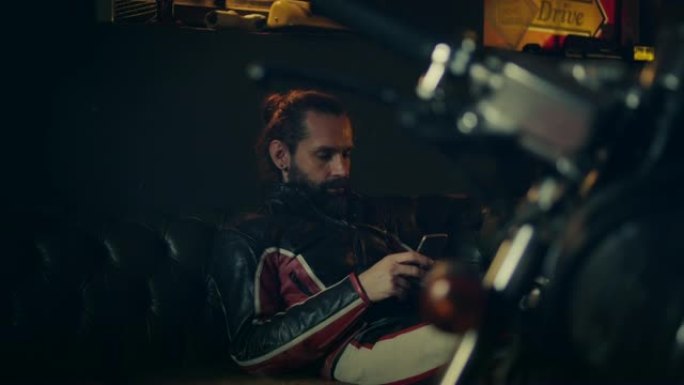 男子在摩托车车间使用智能手机