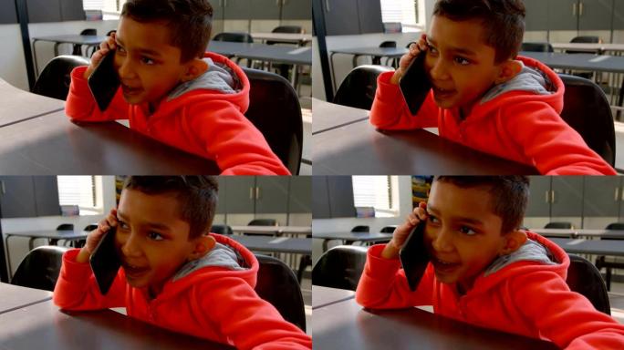 4k学校教室里用手机聊天的亚洲男生的前视图