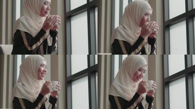 穆斯林女孩在咖啡馆喝茶微笑。