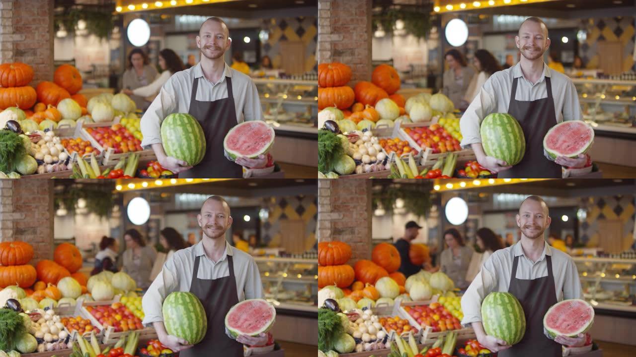 开朗的推销员拿着西瓜在食品市场摆姿势拍照