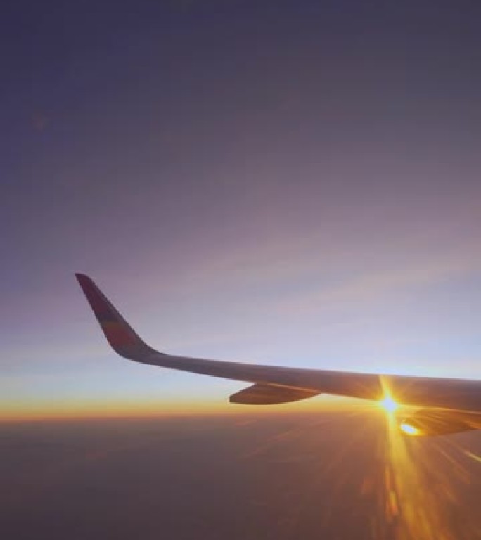 从飞机窗口垂直日出或日落观察飞机机翼