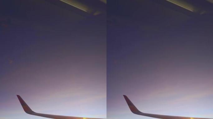 从飞机窗口垂直日出或日落观察飞机机翼
