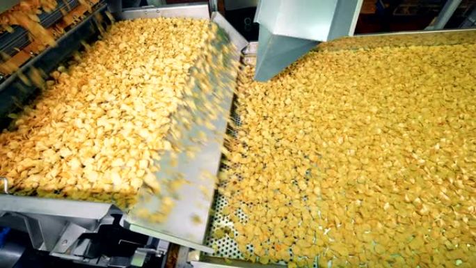 大量的薯片沿着传送带移动。薯片产量。