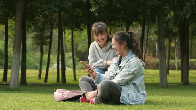 两名亚裔女大学生在校园内使用手机