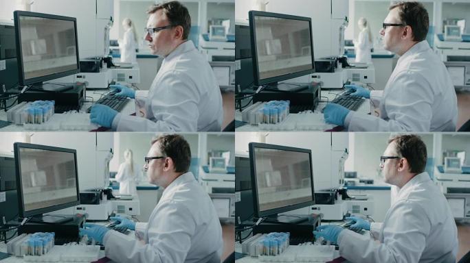 男科学家坐在实验室的工作场所，使用个人计算机。屏幕显示DNA分析。我拥有创新设备的背景遗传学研究中心
