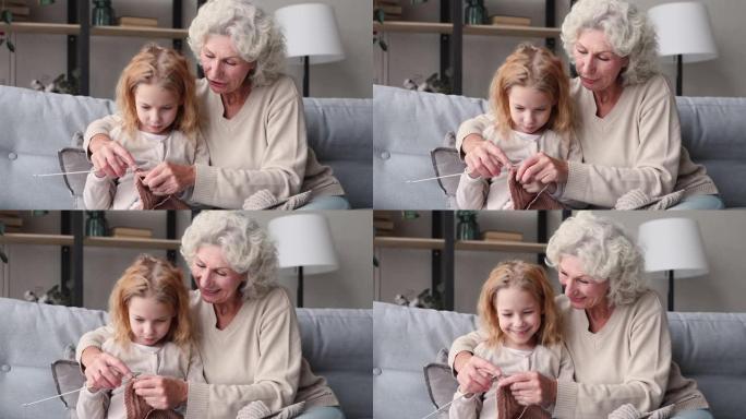 老奶奶在沙发上教可爱的孙女一起编织