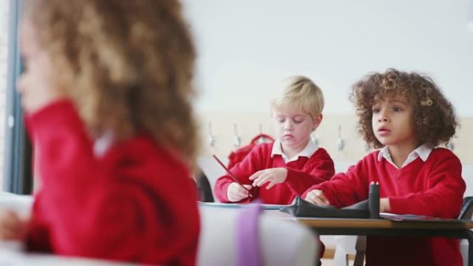 幼儿学校课桌上穿着校服的年轻男生，特写镜头