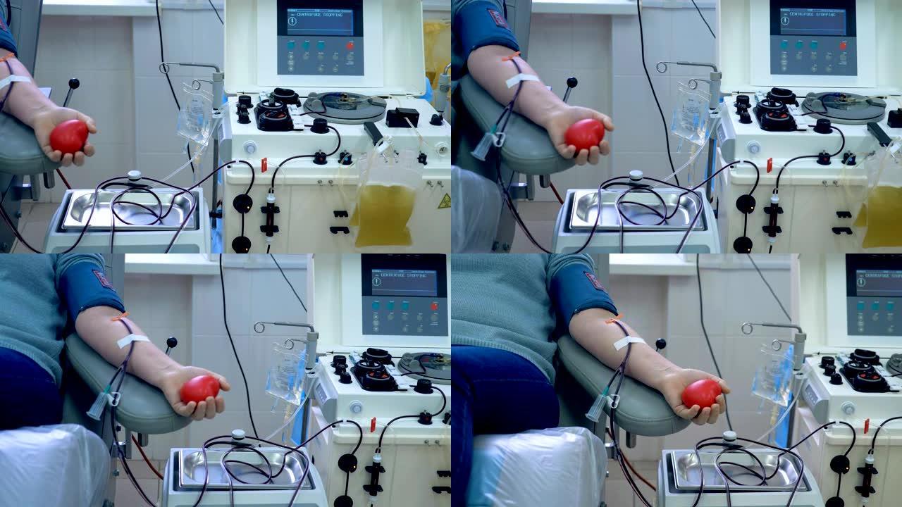 当输血机在诊所工作时，捐献者坐在椅子上。