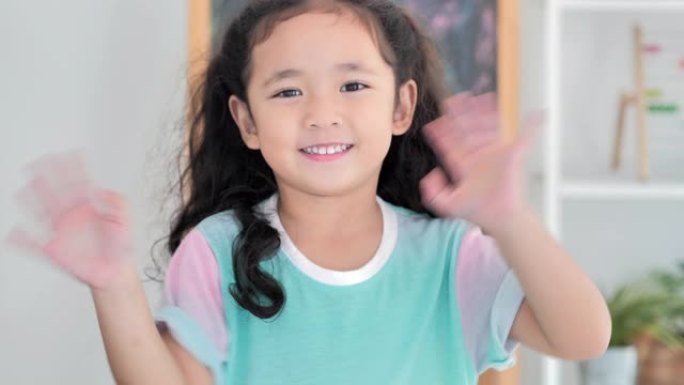 描绘亚洲可爱的小女孩微笑和跳舞呆在家里防止冠状病毒或Covid-19.Homeschooling流行