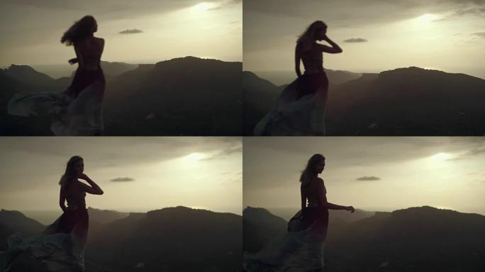 穿着长裙享受风的浪漫女孩。从悬崖上看风景