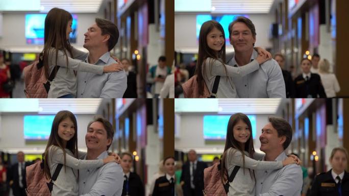 慈爱的父亲带着女儿在机场看着相机微笑