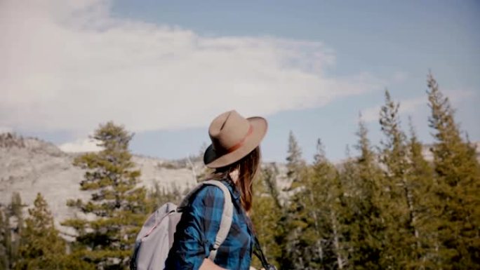年轻漂亮的旅游女孩，背着背包和相机独自在优胜美地国家公园山湖徒步旅行。