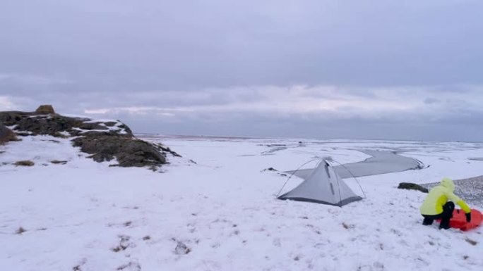 WS妇女在冰岛偏远的积雪覆盖的景观中露营