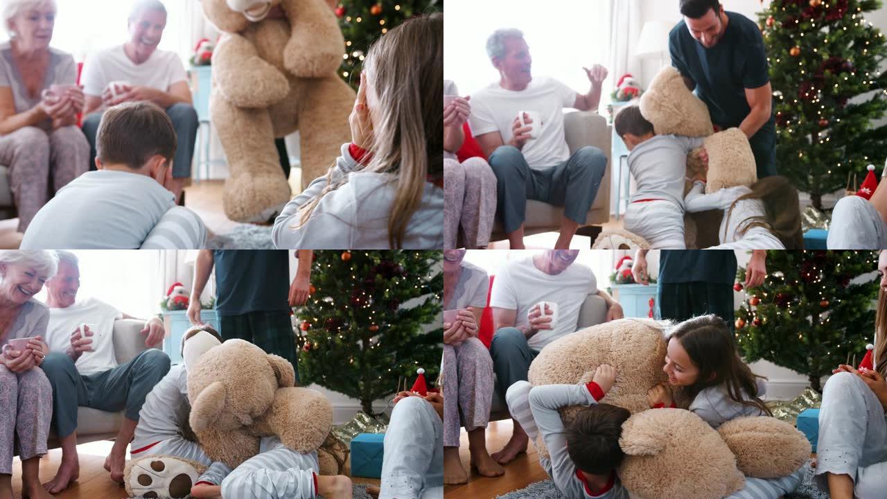 孩子们在圣诞节那天玩巨型泰迪熊作为多代家庭开放礼物