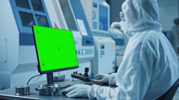 工厂洁净室: 工程师穿着工作服和面罩在计算机上进行系统控制，绿屏色度键显示。背景技术现代数控机械，专