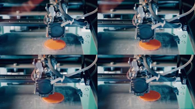 圆形橙色盘子正在3D打印。三维3d打印机在3d打印实验室工作。