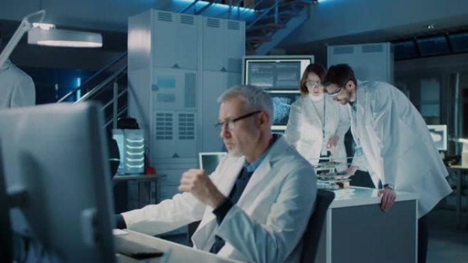 多元化的国际工业科学家和工程师团队穿着白大褂在研究实验室从事重型机械设计。专业人员使用3D打印机、计