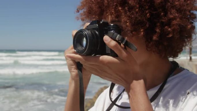 女人在海滩上用数码相机拍照4k