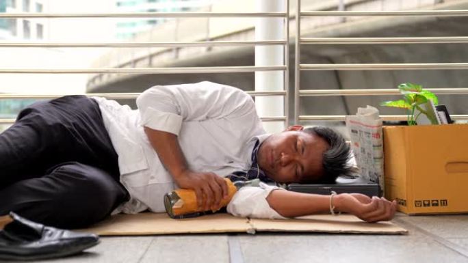 被解雇的上班族男子乞求一份躺在地板上的工作，在街上乞求帮助。经济危机，经济改革理念。白领员工被解雇，