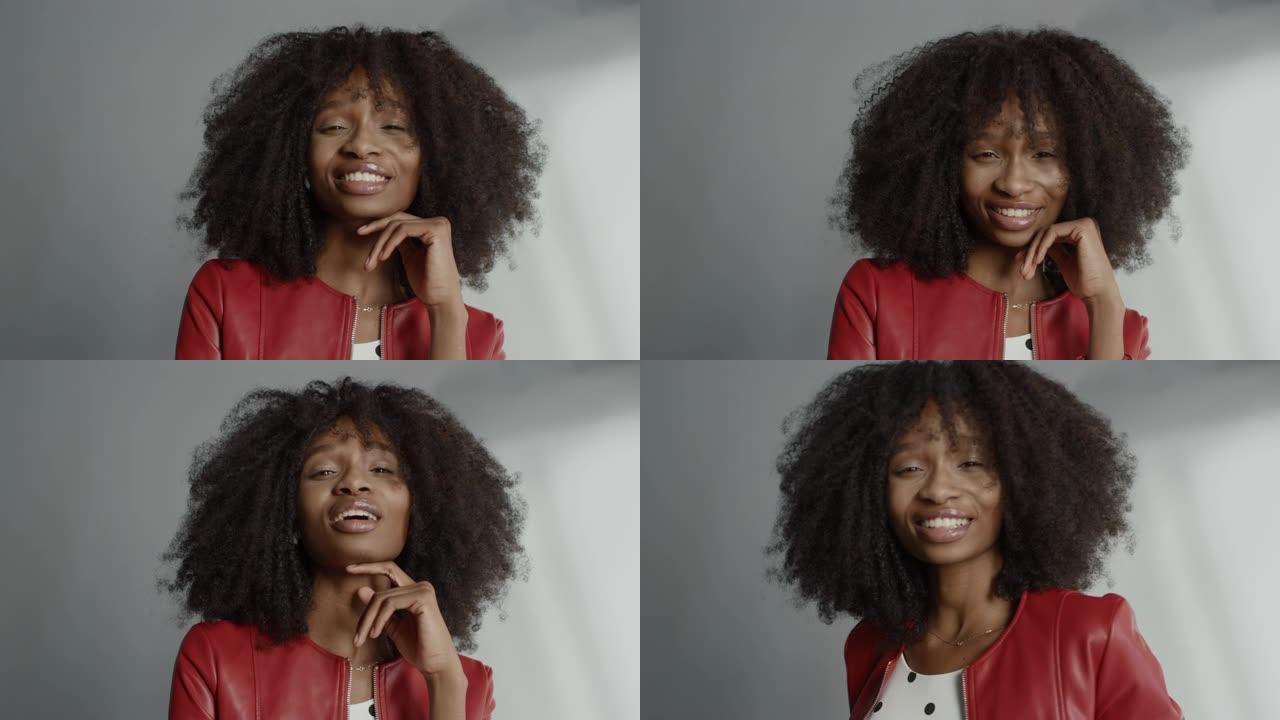 迷人的黑人女孩，郁郁葱葱的卷发摆姿势拍摄时尚杂志照片。美丽的女孩顽皮地微笑着，并在专业工作室拍摄照片
