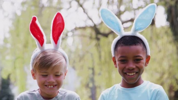 一群戴着兔子耳朵的孩子的肖像在花园里的复活节彩蛋狩猎中微笑着慢动作镜头
