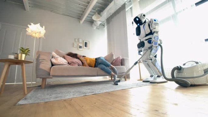 类似人类的机器人正在和一个坐在沙发上的女人打扫房间