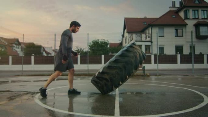 穿着运动服和手套的强壮肌肉健康的年轻人在一个有围栏的室外篮球场上做运动。在一个居民区下雨后的一个下午