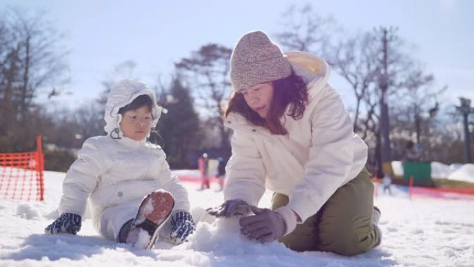 旅游妇女和儿童在雪地里玩耍