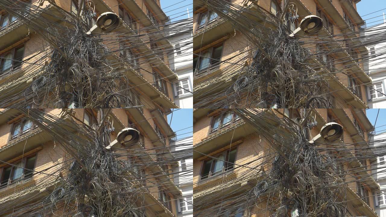 特写:电线混乱地缠在公寓大楼的一边。