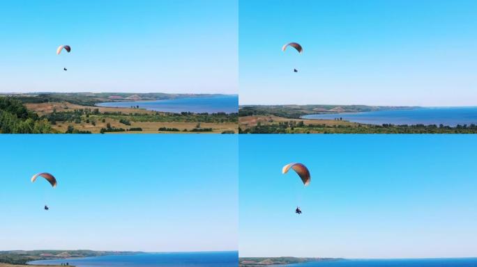 人们在副飞机上飞越陆地和水上。男子滑翔伞。美丽的自然背景。