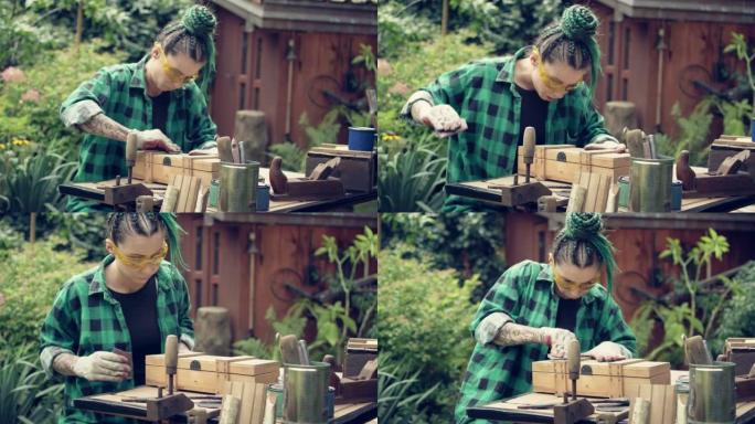 花园DIY。纹身女人抛光木制家具。