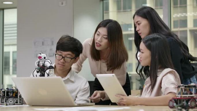 年轻的亚洲创意工程师会议，在笔记本电脑车间为协作通用机器人编程。有技术或创新概念的人。
