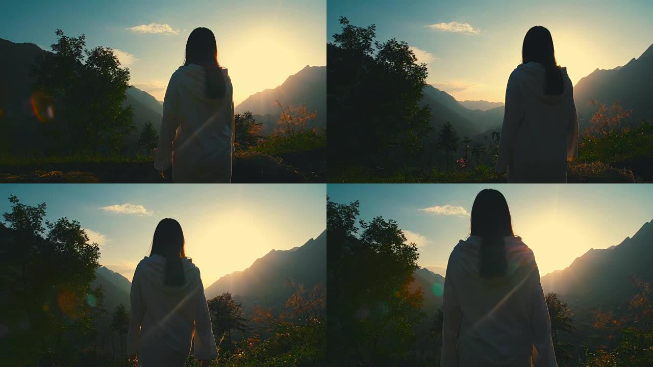 年轻女子在山上走向阳光