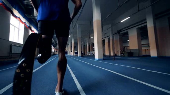 运动员慢跑，戴着仿生假肢，后视图。