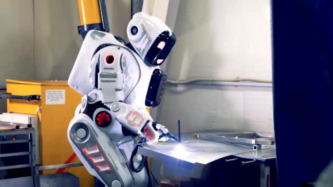 安卓使用工厂设备与金属一起工作，特写。一个机器人在工厂工作，用工具焊接。