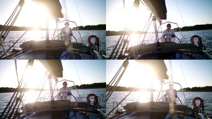 湖上宁静的日落。享受帆船运动的年轻人