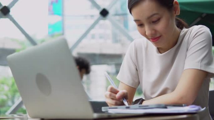 日本妇女在日光咖啡馆使用笔记本电脑