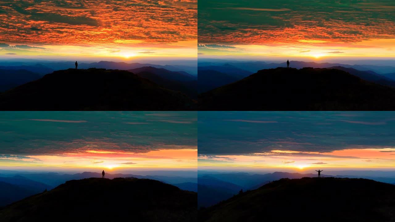 日落背景下山上的男人剪影