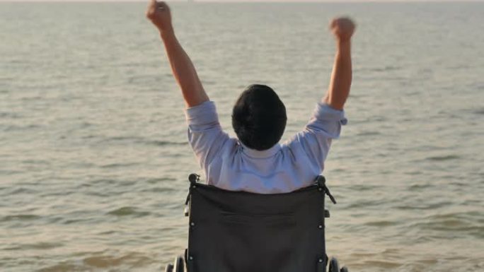 残疾人在轮椅上举起双手的肖像，展示了自由。成功，度假，旅行，人，保险，生活方式，领导力，商业成功。残