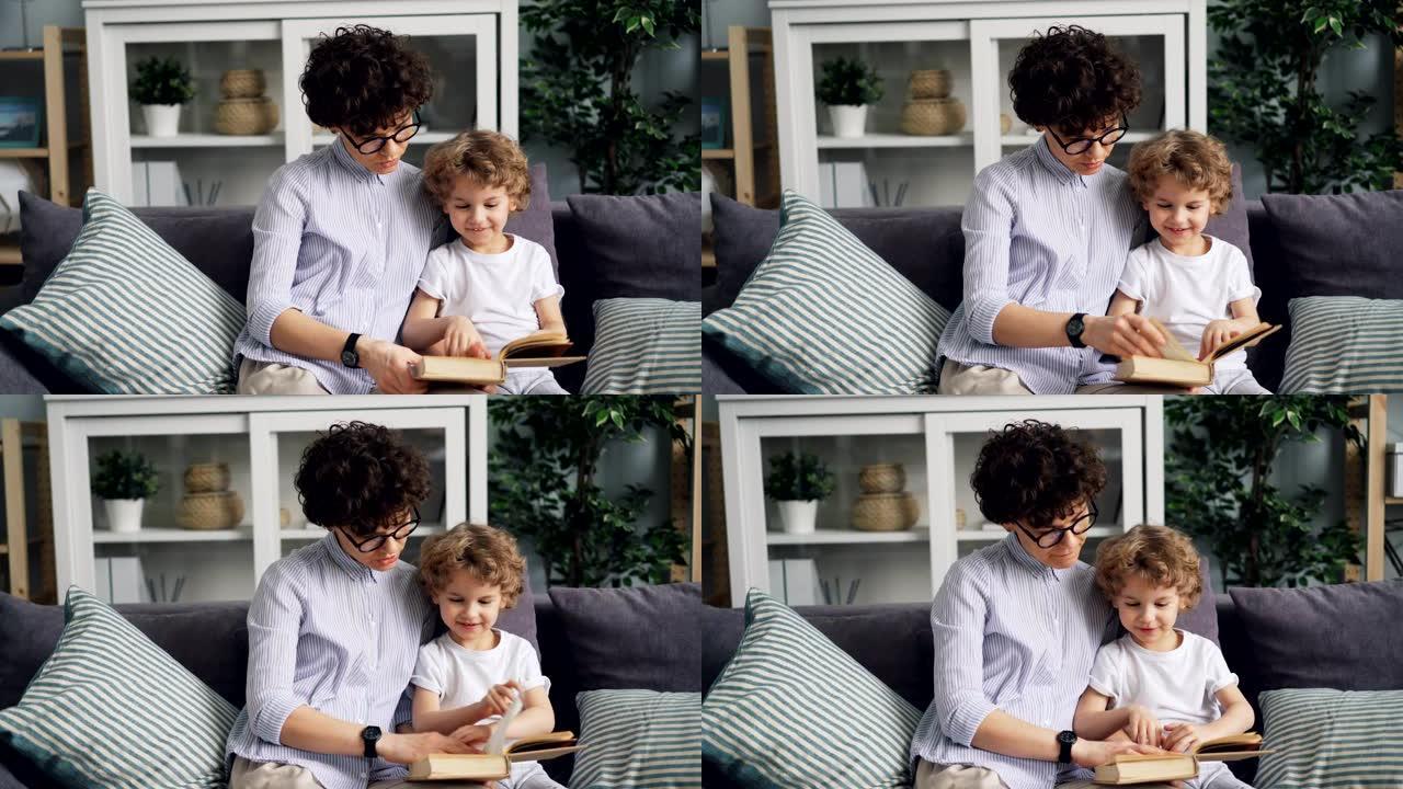 快乐妈妈和可爱的孩子看书在家沙发上看图片