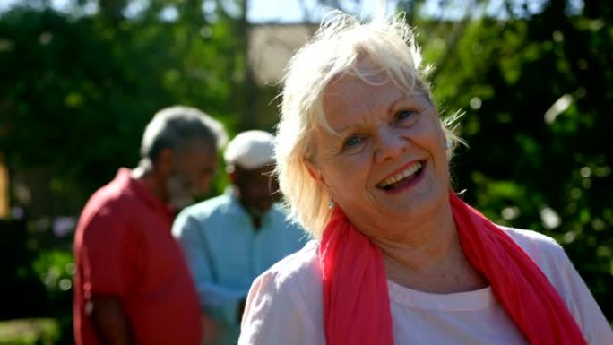 活跃的高加索高级女性在养老院4k花园中微笑的前视图