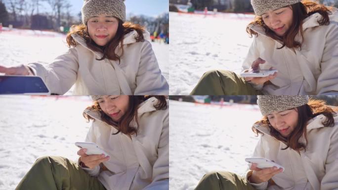 年轻女子在滑雪胜地用智能手机自拍