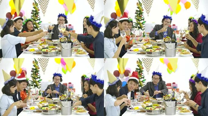 一群亚洲人一起在餐桌上敬酒，并在新年晚会上用美味的饭菜庆祝圣诞节。有节日和庆祝概念的人。