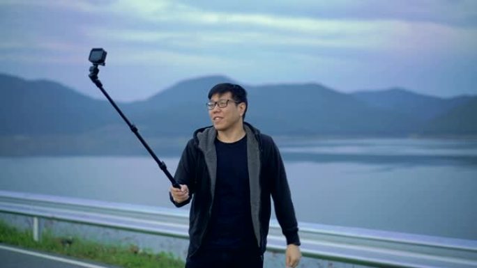 SLOMO-亚洲男子使用自拍杆拍摄视频
