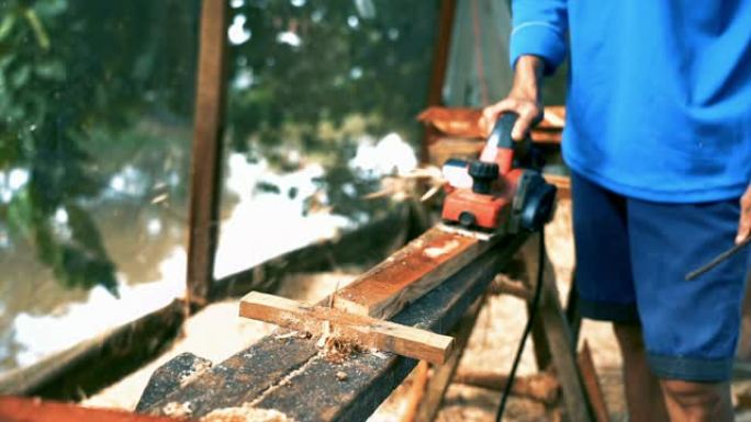 越南东塔丁延的亚洲工人用规划机刨削木材的4k慢动作镜头，木工工具和机器概念