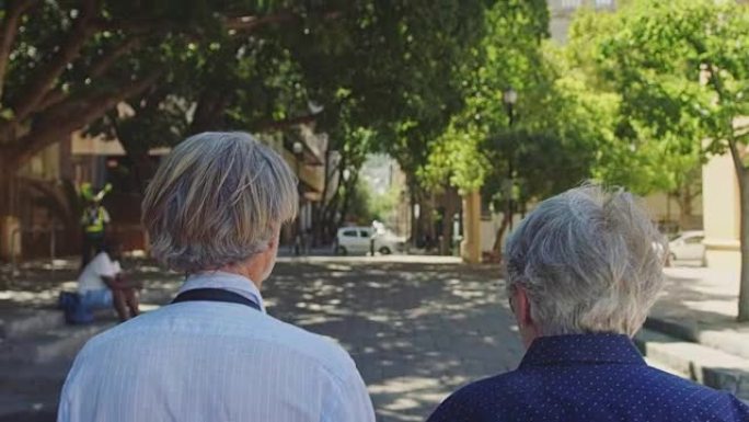充满爱心的老年夫妇带着包走在街上