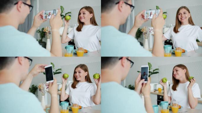 当男人用智能手机拍照时，女人与苹果合影的慢动作