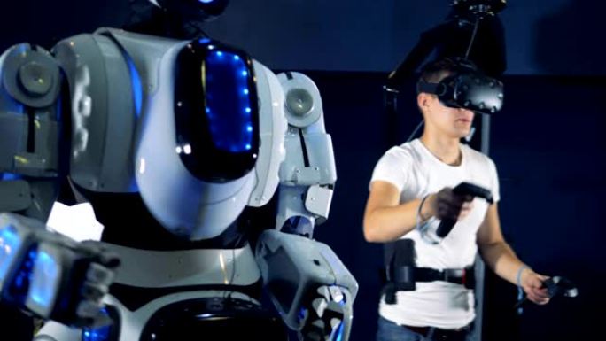 一个人正在用虚拟现实装置操纵机器人。虚拟现实游戏概念。