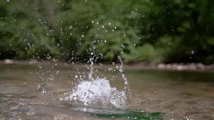 慢动作: 空的绿色玻璃瓶从天而降，落入河中。